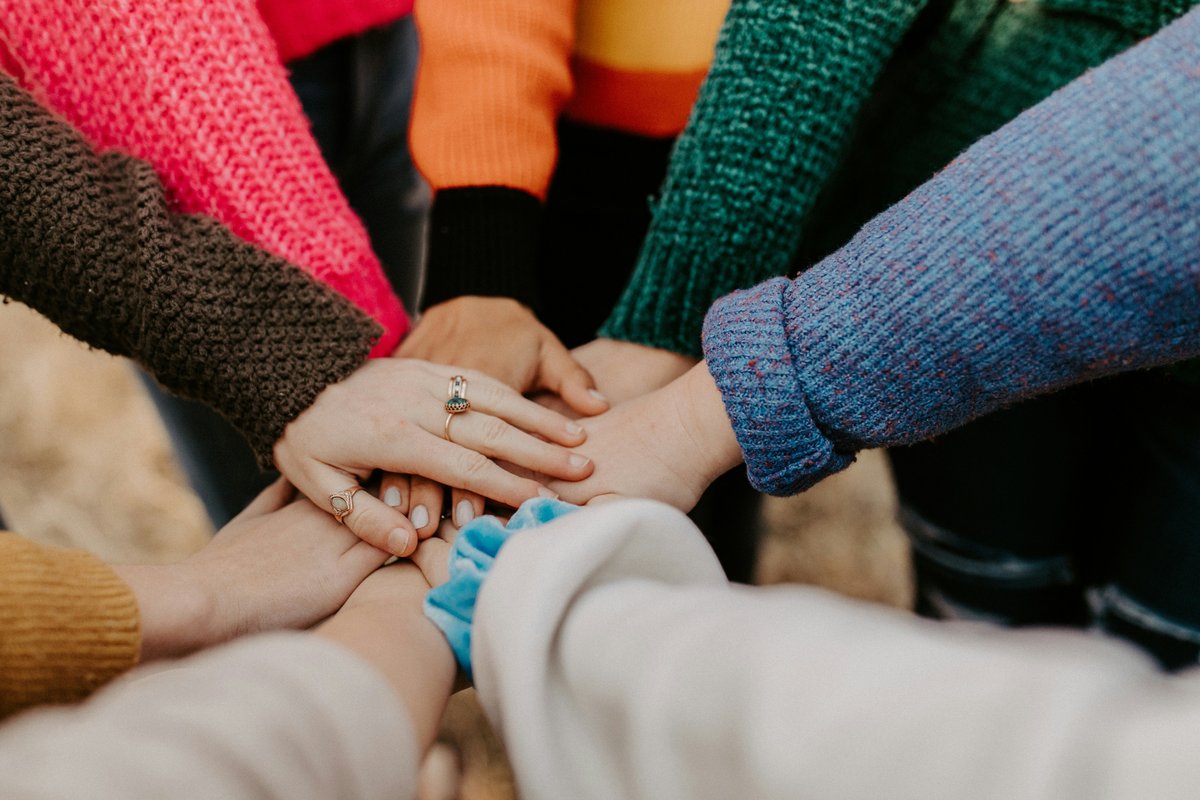 Group of people placing hands together